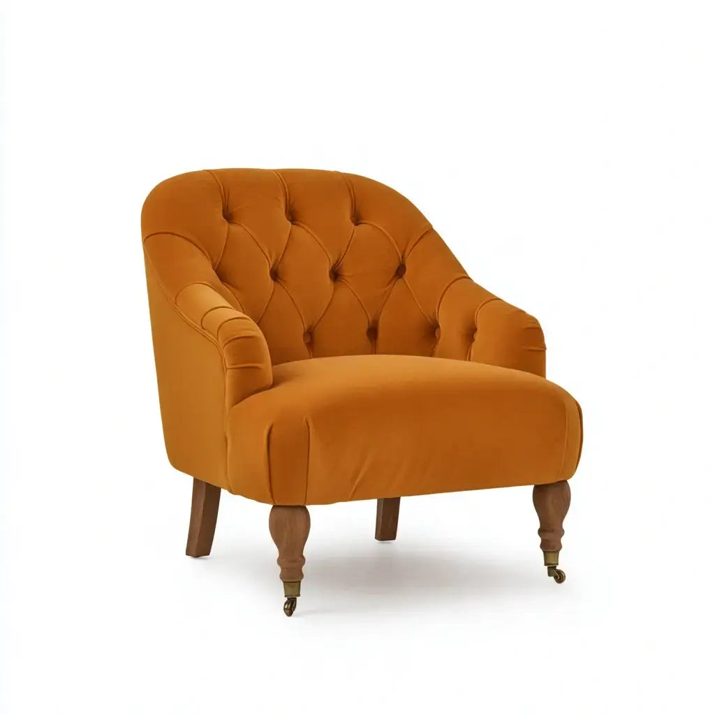 Orange button-back armchair with curved arms and stylish design by CraftandCrux, shown from a side angle.